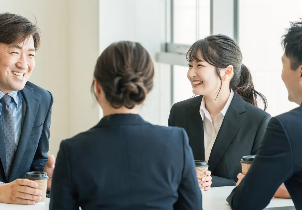 会議室で談笑しているビジネスマン（男女）